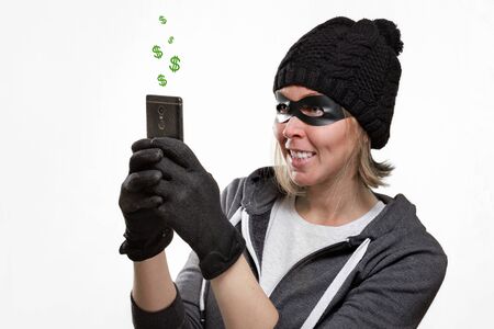 The concept of cybercrime and hacking. Portrait of a woman in a black hat, gloves and mask, who is...