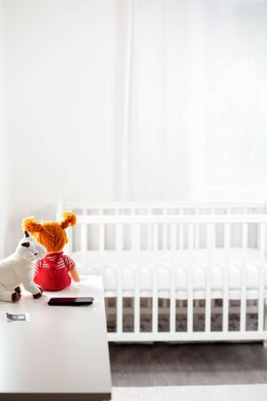 Children's white room with toys and a cradle. Copy space. Concept of family planning, pregnancy and...