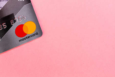 Bank card ,,MasterCard,, on a pink background. Close up. Copy space. Concept of banking operationsのeditorial素材