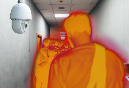 A queue of people in a narrow space under the supervision of a video camera in a color filter. Rear view. CCTV concept.の写真素材