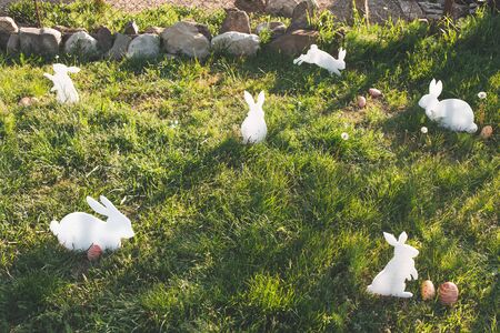 The concept of Easter holidays. Decorative handmade crafts in the form of white rabbits and colorful...