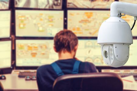 The concept of video surveillance. Surveillance camera on the background of a blurry man looking at the monitors.の写真素材