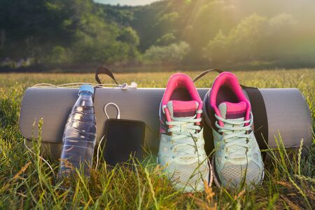 sneakers,water bottle and a phone pad on a background of mountains.の写真素材