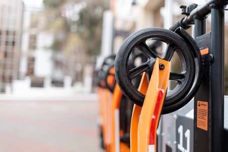 The eco-vehicles. Orange electric scooter in a row located at the city transport rental counter....