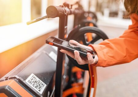 ECO-friendly vehicle.A person holds a smartphone in his hands and reads the code on the information panel. Qr-code. Modern technology.の写真素材