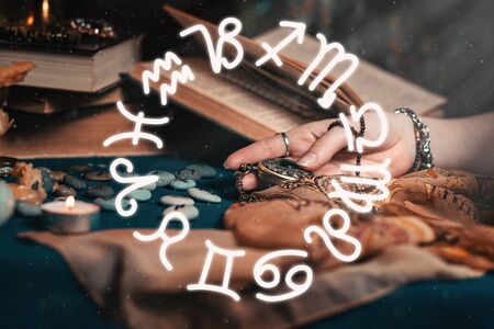 Astrology and esotericism. The female hand of the sorceress holds an amulet in her hands. In the...
