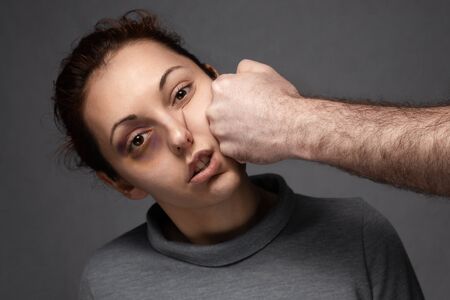 A man's fist hits a woman in the face. Domestic violence.の写真素材