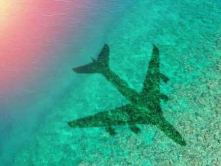 The concept of air travel. Top view of the ocean or sea, with the shadow of a flying plane. Copy space.の写真素材