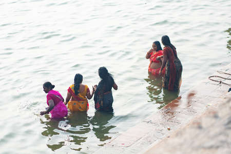 December 17 2019 Varanasi, India. A group of Indian women perform a sacred ablution in the Ganges river. Top view from the back.のeditorial素材