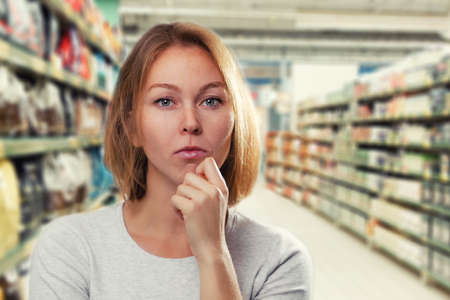 Emotions and psychology. The woman, a blonde with glasses, crossed her arms and pursed her lips with a disgruntled face. Disagreement. Close up.の写真素材