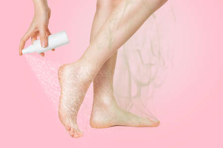 Women's smooth legs with a smell coming from them, shown in profile, on which the medicine is sprayed. Pink background. The concept of the treatment of foot fungus.の写真素材