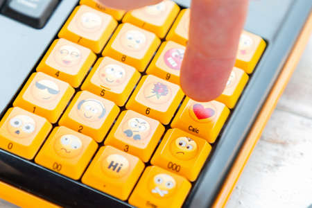 A finger presses a button with a heart sign on the keyboard. Close up. Concept of social networks, communication and emotions.の写真素材