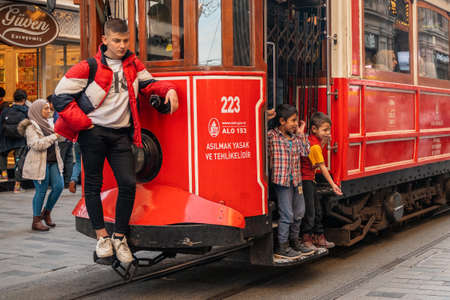 23.10.2019 Istanbul, Turkey. Vintage red tram rides down the street in Istanbul, behind the tram...