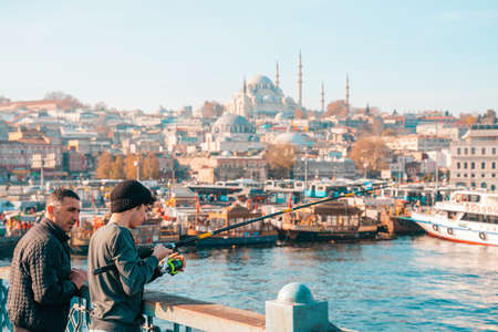 10/23/2019 Istanbul, Turkey. Two men fishing. In the background, a view of Hagia Sophia and the Bay.のeditorial素材