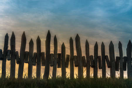 a fence made of wooden peak at sunset.の写真素材