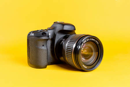 Professional SLR camera on a yellow background. Digital electronics.の写真素材