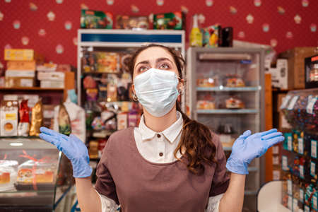 Small businesses during the pandemic. A female worker in a medical mask and rubber gloves, spreads...