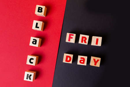On a red and black background are wooden cubes with the inscription black Friday. Flat lay. Close...