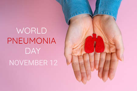 World pneumonia day, 12th November. Woman's hands hold the cut-out silhouette of the lungs. Flat...