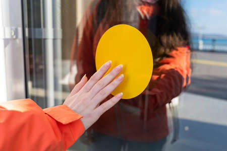 International day of the blind. A yellow circle on the door that a blind woman touches. The concept of blindness and disability.の写真素材