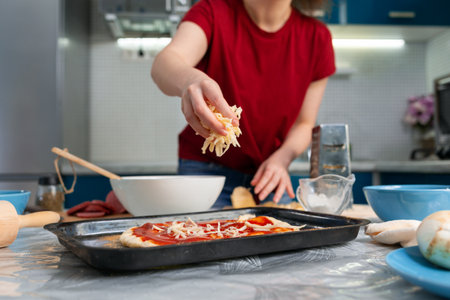 A young woman cooking a pizza. Hands close-up. Homemade cooking concept.の写真素材