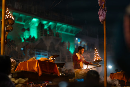 12/17/2019, Varanasi, India. Sacred religious ceremony Arati in the temple. A hindu man burn a lamp fire. Night. Outdoor.のeditorial素材