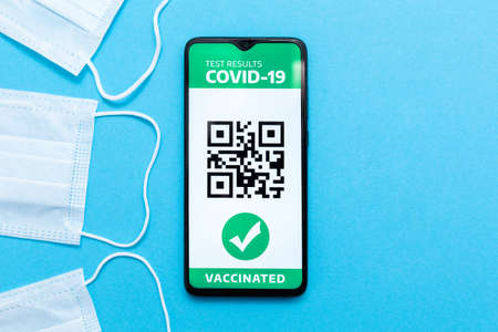 Electronic Immunity passport with a COVID-19 vaccination stamp and qr-code on a smartphone screen...
