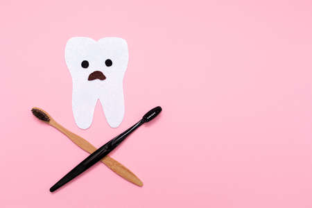 Care for the oral cavity. A startled tooth, cut out of felt with crossed toothbrushes, in the shape...