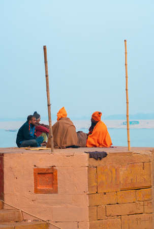 12/17/2019, Varanasi, India. A group of men sit on the roof of a building. The sky is in the background.のeditorial素材