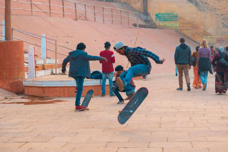 12/17/2019, Varanasi, India. A group of teenage boys ride a skateboard on the street.のeditorial素材