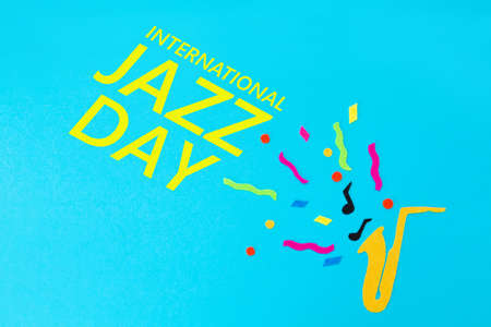 Festival and holiday. A cutted out of felt saxophone on a blue background. Flat lay. International...