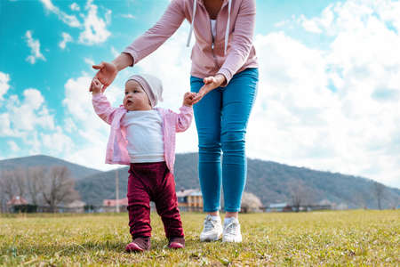 The first steps. Mother teaches the child to walk. View from the lower angle. The concept of child...