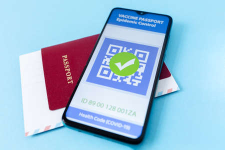 Close up view of electronic Immunity passport with a COVID-19 vaccination stamp on a smartphone screen with passport. Concept of travel during pandemic.の写真素材