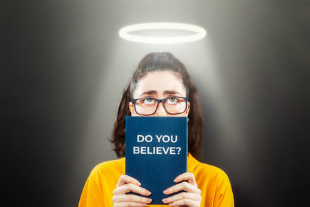 Religion.Portrait of a woman on a dark background, looking up from behind a book.Inscription on the...