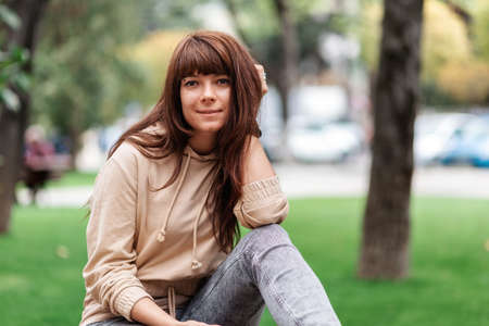 Portrait of a young caucasian woman posing in a park.の写真素材