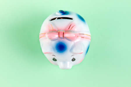 Piggy Bank white polka dot, flat lay. Turquoise background. Copy space. Concept of financial savings and Bank investments.の写真素材