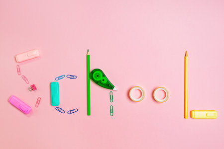 Back to school concept. The inscription is made up of multi-colored stationery. Pink background. Flat lay.の写真素材