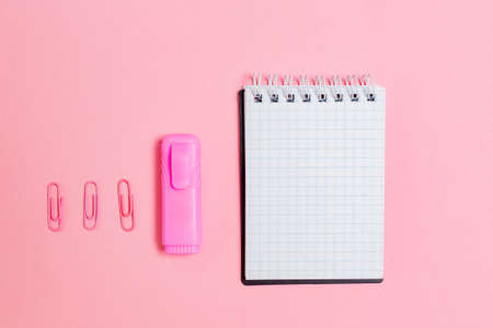 Back to school. Notepad, marker and clips on pink background. Flat lay. Mock up. Copy space. Concept...