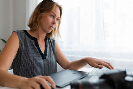 Business and creativity. A young woman is working intently at the computer.Near the camera and tablet.の写真素材