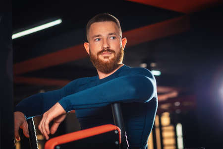 Portrait of a sporty bearded man posing in a gym. Concept of fitness.の写真素材