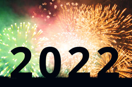 New Year 2022. Silhouette of large black numbers against a background of multicolored fireworks....
