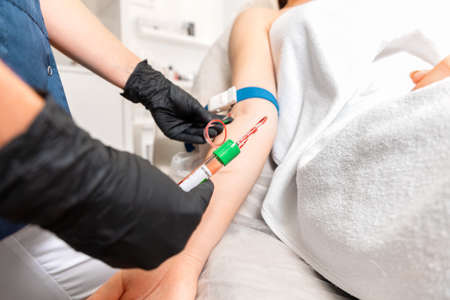 Cosmetology and health. Beautician makes blood sampling from the client's hand for the plasmolifting...