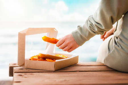 A woman takes out a dried homemade pastille from a cardboard box with her hands. Close-up. Concept of natural sugar free sweets.の写真素材
