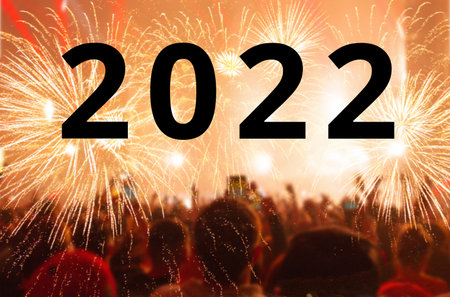 New Year 2022. A crowd of people looks at the festive golden fireworks. Rear view. New Year's Eve.