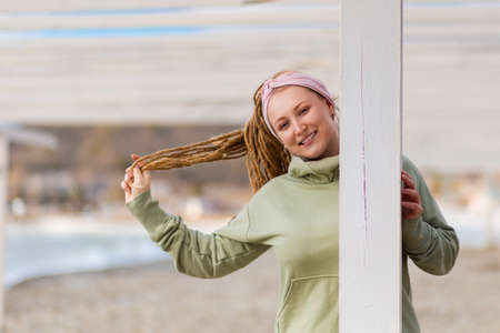 Portrait of a young funny woman with dreadlocks posing against a ocean. The concept of psychology.