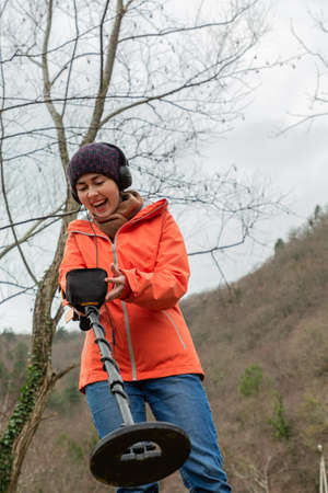 a young girl rejoices at what the metal detector indicates.