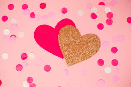 Pink and gold heart cut out of felt on a background with scattered confetti. flat lay. Valentine's Day Concept.の写真素材