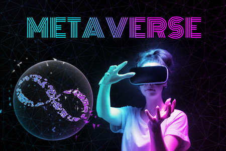 augmented reality. Portrait of young woman in VR glasses creates 3D simulation of sphere with sign of . Black background. The concept of virtual reality and cyberspace.の写真素材