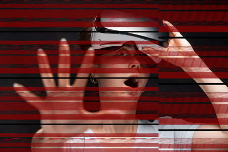 Portrait of young had shocked screaming woman removing VR glasses and reaching hand. Red stripes of...