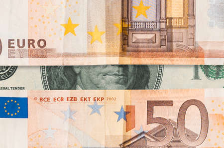 stock exchange. Dollar and euro banknotes, with Benjamin Franklin's mouth between paper currency, horizontal opening. Flat lay, close up. The concept of the global crisis, investment and trading.の写真素材